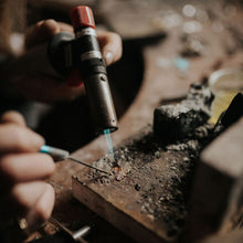 Person using a torch on a piece of metal in a workshop setting
