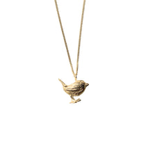A gold bird necklace on a white background.