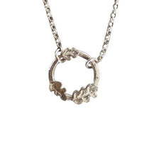 A dainty silver necklace with a hoop pendant decorated with 3 tiny engraved oak leaves on a white background